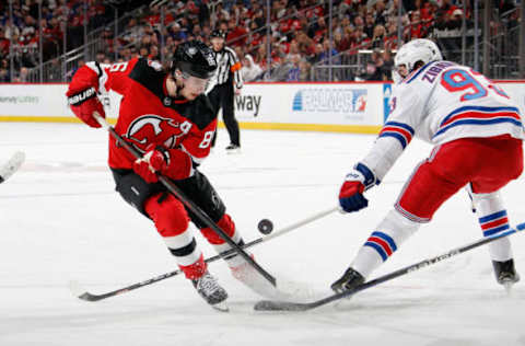 NEWARK, NEW JERSEY – APRIL 18: Jack Hughes #86 of the New Jersey Devils carries the puck past Mika Zibanejad #93 of the New York Rangers during the second period of Game One in the First Round of the 2023 Stanley Cup Playoffs at the Prudential Center on April 18, 2023, in Newark, New Jersey. (Photo by Bruce Bennett/Getty Images)