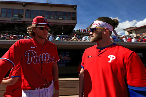 Alec Bohm speaks with Bryce Harper #3 of the Philadelphia Phillies (Photo by Carmen Mandato/Getty Images)