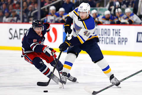 Jan 30, 2023; Winnipeg, Manitoba, CAN; St. Louis Blues center Ivan Barbashev (49) is checked by Winnipeg Jets right wing Saku Maenalanen (8) in the first period at Canada Life Centre. Mandatory Credit: James Carey Lauder-USA TODAY Sports