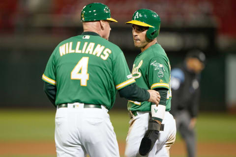 Jul 16, 2019; Oakland, CA, USA; Oakland Athletics third base coach Matt Williams (4) speaks with center fielder Ramon Laureano (22) in the game against the Seattle Mariners during the eighth inning at the Oakland Coliseum. Mandatory Credit: Stan Szeto-USA TODAY Sports