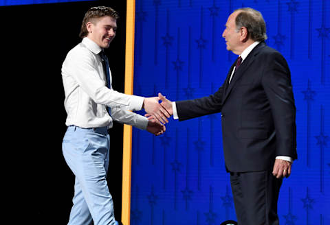 Jun 28, 2023; Nashville, Tennessee, USA; Buffalo Sabres draft pick Zach Benson shakes hands with NHL commissioner Gary Bettman after being selected with the thirteenth pick in round one of the 2023 NHL Draft at Bridgestone Arena. Mandatory Credit: Christopher Hanewinckel-USA TODAY Sports