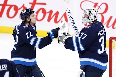 Winnipeg Jets, Austin Poganski (22) and Connor Hellebuyck (37). Mandatory Credit: James Carey Lauder-USA TODAY Sports