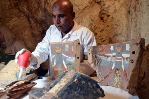 An Egyptian archaeological technician restores artifacts found at the newly discovered 'Kampp 161' tomb at Draa Abul Naga necropolis on the west Nile bank of the southern Egyptian city of Luxor, about 400 miles south of the capital Cairo, on December 9, 2017.