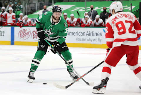 DALLAS, TEXAS – JANUARY 26: Jason Dickinson #18 of the Dallas Stars skates the puck against Vladislav Namestnikov #92 of the Detroit Red Wings in overtime at American Airlines Center on January 26, 2021 in Dallas, Texas. (Photo by Ronald Martinez/Getty Images)