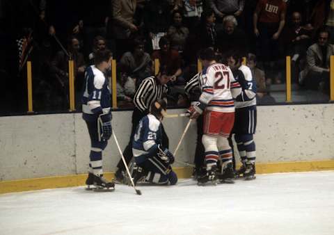 NEW YORK, NY – 1973: Ted Irvine #27 of the New York Rangers looks down at Eddie Shack #23 of the Pittsburgh Penguins as Shack’s teammates Nick Harbaruk #11 and Bryan Hextall #11 talk to the refs circa 1973 at the Madison Square Garden in New York, New York. (Photo by Melchior DiGiacomo/Getty Images)