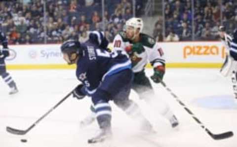 Sep 29, 2016; Winnipeg, Manitoba, CAN; Winnipeg Jets defenceman Mark Stuart (5) battles for the puck with Minnesota Wild center Jordan Schroeder (10) during the first period during a preseason hockey game at MTS Centre. Mandatory Credit: Bruce Fedyck-USA TODAY Sports