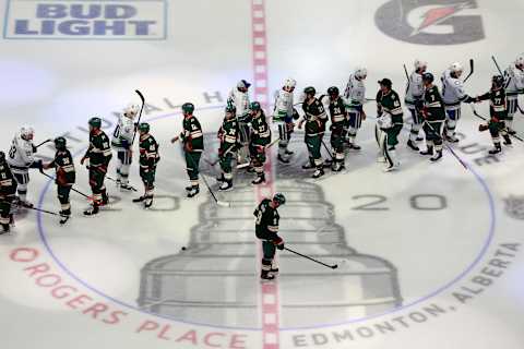 Vancouver Canucks and Minnesota Wild shake hands following the Canucks win (Photo by Jeff Vinnick/Getty Images)