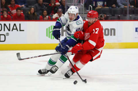 DETROIT, MICHIGAN – OCTOBER 22: Quinn Hughes #43 of the Vancouver Canucks tries to get around the stick of Filip Hronek #17 of the Detroit Red Wings during the third period at Little Caesars Arena on October 22, 2019 in Detroit, Michigan. Vancouver won the game 5-2. (Photo by Gregory Shamus/Getty Images)