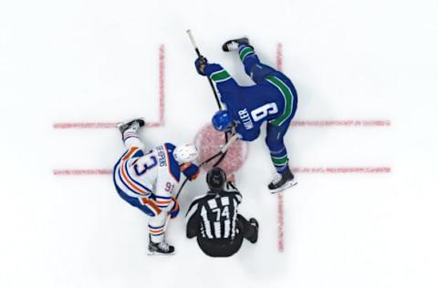 VANCOUVER, CANADA – OCTOBER 11: Ryan Nugent-Hopkins #93 of the Edmonton Oilers faces off against J.T. Miller #9 of the Vancouver Canucks during the first period of their NHL game at Rogers Arena on October 11, 2023 in Vancouver, British Columbia, Canada. (Photo by Derek Cain/Getty Images)