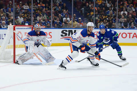 VANCOUVER, CANADA – OCTOBER 11: Jack Campbell #36 and Darnell Nurse #25 of the Edmonton Oilers defend against Andrei Kuzmenko #96 of the Vancouver Canucks during the first period of their NHL game at Rogers Arena on October 11, 2023 in Vancouver, British Columbia, Canada. (Photo by Derek Cain/Getty Images)