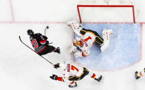 Feb 26, 2017; Raleigh, NC, USA; Calgary Flames goalie Brian Elliott (1) stops the shot by Carolina Hurricanes forward Sebastian Aho (20) at PNC Arena. The Calgary Flames defeated the Carolina Hurricanes 3-1. Mandatory Credit: James Guillory-USA TODAY Sports