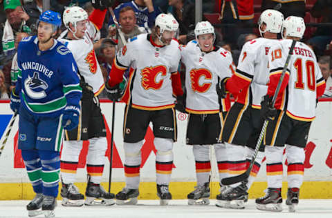 VANCOUVER, BC – OCTOBER 14: Michael Del Zotto #4 of the Vancouver Canucks looks on as Johnny Gaudreau #13 of the Calgary Flames is congratulated after scoring during their NHL game at Rogers Arena October 14, 2017 in Vancouver, British Columbia, Canada. (Photo by Jeff Vinnick/NHLI via Getty Images)