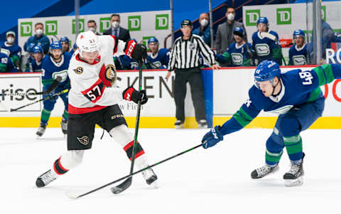 VANCOUVER, BC – APRIL 22: Olli Juolevi #48 of the Vancouver Canucks tries to defend against the shot of Shane Pinto #57 of the Ottawa Senators during NHL action at Rogers Arena on April 22, 2021 in Vancouver, Canada. (Photo by Rich Lam/Getty Images)