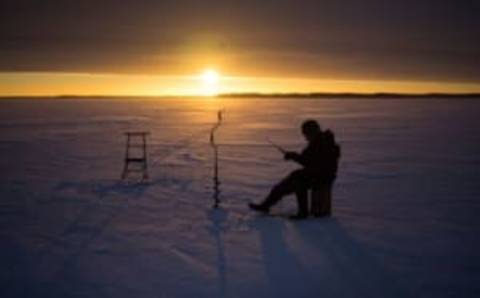 TOPSHOT – A man fishes through the ice on January 17, 2017 at sunrise on the frozen sea in Vaasa by -15°C. (Photo by OLIVIER MORIN / AFP) (Photo by OLIVIER MORIN/AFP via Getty Images)