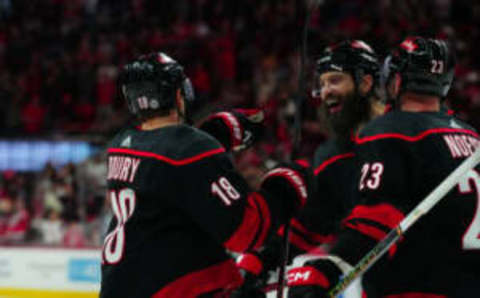 Dec 2, 2023; Raleigh, North Carolina, USA; Carolina Hurricanes center Jack Drury (18) is congratulated by Carolina Hurricanes defenseman Brent Burns (8) and Carolina Hurricanes right wing Stefan Noesen (23) after his goal against the Buffalo Sabres during the first period at PNC Arena. Mandatory Credit: James Guillory-USA TODAY Sports