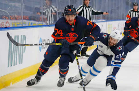 May 19, 2021; Edmonton, Alberta, CAN; Edmonton Oilers defensemen Ethan Bear (74) and Winnipeg Jets defensemen Derek Forbort (24) chase a loss puck during the third period in game one of the first round of the 2021 Stanley Cup Playoffs at Rogers Place. Mandatory Credit: Perry Nelson-USA TODAY Sports