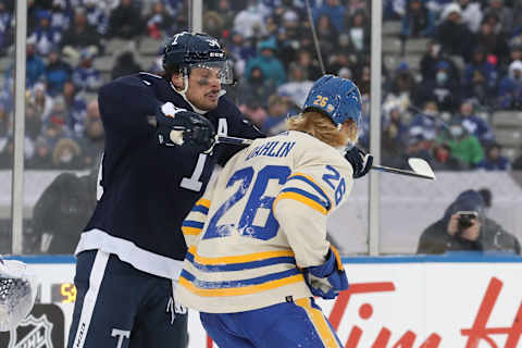 HAMILTON, ONTARIO – MARCH 13: Morgan Rielly #44 of the Toronto Maple Leafs cross checks Rasmus Dahlin #26 of the Buffalo Sabres in the third period during the Heritage Classic at Tim Hortons Field on March 13, 2022 in Hamilton, Ontario. (Photo by Claus Andersen/Getty Images)