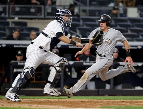 NEW YORK, NY – APRIL 17: J.T. Realmuto #11 of the Miami Marlins slides home safely as Gary Sanchez #24 of the New York Yankees defends in the eighth inning at Yankee Stadium on April 17, 2018 in the Bronx borough of New York City. (Photo by Elsa/Getty Images)