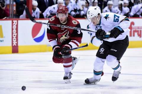 Jan 21, 2016; Glendale, AZ, USA; San Jose Sharks center Tommy Wingels (57) carries the puck as Arizona Coyotes defenseman Klas Dahlbeck (34) defends during the third period at Gila River Arena. Mandatory Credit: Matt Kartozian-USA TODAY Sports