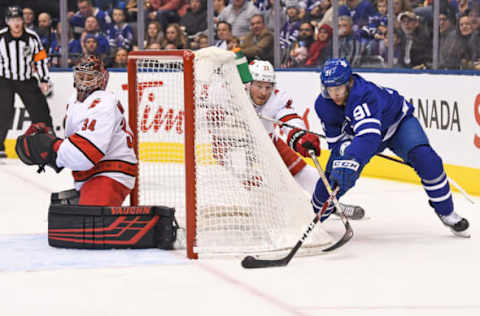 TORONTO, ON – DECEMBER 23: Toronto Maple Leafs Center John Tavares (91) tries to wrap the puck around the back of the net in front of Carolina Hurricanes Goalie Petr Mrazek (34) during the regular season NHL game between the Carolina Hurricanes and Toronto Maple Leafs on December 23, 2019 at Scotiabank Arena in Toronto, ON. (Photo by Gerry Angus/Icon Sportswire via Getty Images)