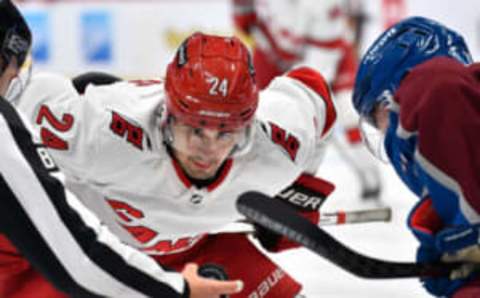 Oct 21, 2023; Denver, Colorado, USA; Carolina Hurricanes center Seth Jarvis (24) keeps his eye on the puck during a face off with Colorado Avalanche center Fredrik Olofsson (22) during the third period at Ball Arena. Mandatory Credit: John Leyba-USA TODAY Sports