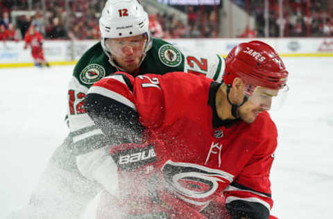 RALEIGH, NC – MARCH 23: Minnesota Wild Center Eric Staal (12) and Carolina Hurricanes Left Wing Nino Niederreiter (21) battle for a loose puck during a game between the Minnesota Wild and the Carolina Hurricanes at the PNC Arena in Raleigh, NC on March 23, 2019. (Photo by Greg Thompson/Icon Sportswire via Getty Images)