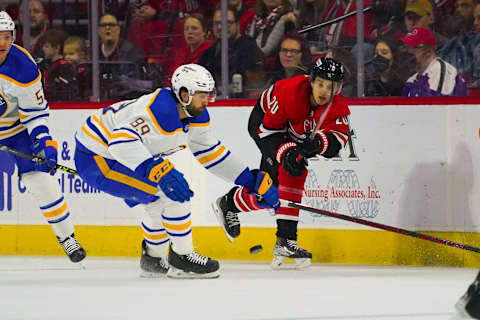 Apr 7, 2022; Raleigh, North Carolina, USA; Carolina Hurricanes center Sebastian Aho (20) moves the puck away from Buffalo Sabres right wing Alex Tuch (89) during the first period at PNC Arena. Mandatory Credit: James Guillory-USA TODAY Sports