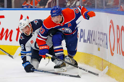 Oct 21, 2023; Edmonton, Alberta, CAN; Edmonton Oilers forward Ryan Nugent-Hopkins (93) and Winnipeg Jets defensemen Nate Schmidt (88) try to find a loose piece during the third period at Rogers Place. Mandatory Credit: Perry Nelson-USA TODAY Sports