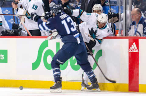 WINNIPEG, MB – FEBRUARY 5: Brandon Tanev #13 of the Winnipeg Jets checks Evander Kane #9 of the San Jose Sharks against the boards during first period action at the Bell MTS Place on February 5, 2019 in Winnipeg, Manitoba, Canada. (Photo by Jonathan Kozub/NHLI via Getty Images)