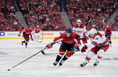 WASHINGTON, DC – APRIL 11: Dmitry Orlov #9 of the Washington Capitals skates with the puck against Brett Pesce #22 of the Carolina Hurricanes in the third period in Game One of the Eastern Conference First Round during the 2019 NHL Stanley Cup Playoffs at Capital One Arena on April 11, 2019 in Washington, DC. (Photo by Patrick McDermott/NHLI via Getty Images)