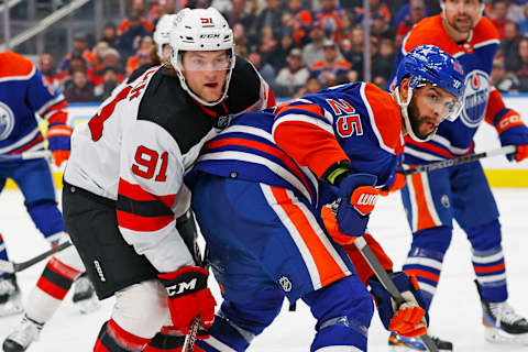 Dec 10, 2023; Edmonton, Alberta, CAN; New Jersey Devils forward Dawson Mercer (91) and Edmonton Oilers defensemen Darnell Nurse (25) battles for position during the second period at Rogers Place. Mandatory Credit: Perry Nelson-USA TODAY Sports