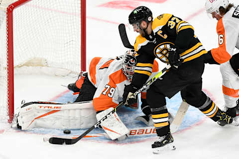 Jan 21, 2021; Boston, Massachusetts, USA; Philadelphia Flyers goaltender Carter Hart (79) blocks a shot from Boston Bruins center Patrice Bergeron (37) during the second period at the TD Garden. Mandatory Credit: Brian Fluharty-USA TODAY Sports