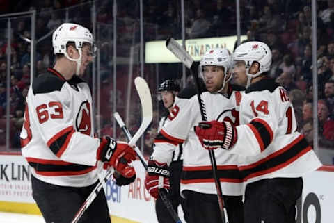 Sep 26, 2016; Montreal, Quebec, CAN; New Jersey Devils forward Adam Henrique (14) reacts with teammates Nathan Bastian (63) and Taylor Hall (9) after scoring a goal against the Montreal Canadiens during the second period of a preseason hockey game at the Bell Centre. Mandatory Credit: Eric Bolte-USA TODAY Sports