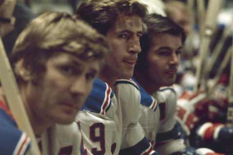 Canadian ice hockey players Vic Hadfield (left), Jean Ratelle (center), and Rod Gilbert of the New York Rangers sit together on the bench during a game, 1960s or early 1970s. (Photo by Melchior DiGiacomo/Getty Images)