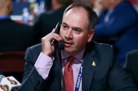 VANCOUVER, BRITISH COLUMBIA – JUNE 22: General manager Pierre Dorion of the Ottawa Senators talks on the phone on the draft floor during Rounds 2-7 of the 2019 NHL Draft at Rogers Arena on June 22, 2019 in Vancouver, Canada. (Photo by Jeff Vinnick/NHLI via Getty Images)