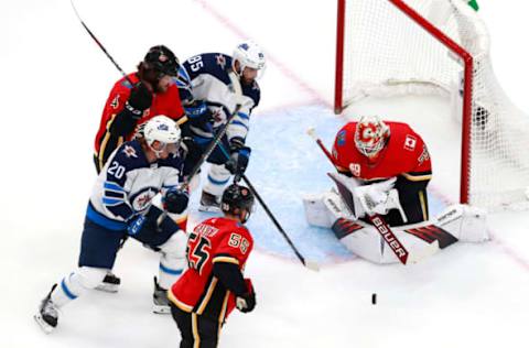 EDMONTON, ALBERTA – AUGUST 03: Cam Talbot #39 of the Calgary Flames stops a shot by Mathieu Perreault #85 of the Winnipeg Jets as Cody Eakin #20 of the Winnipeg Jets and Rasmus Andersson #4 and Noah Hanifin #55 of the Calgary Flames defend in the first period during Game Two of the Western Conference Qualification Round prior to the 2020 NHL Stanley Cup Playoffs at Rogers Place on August 03, 2020 in Edmonton, Alberta. (Photo by Jeff Vinnick/Getty Images)