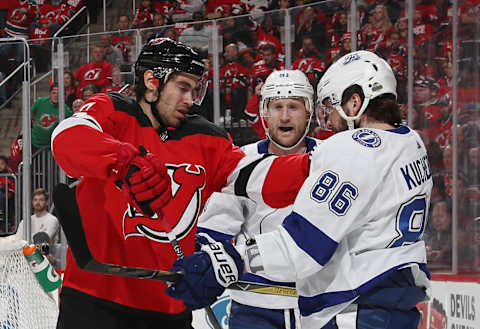 John Moore #2 of the New Jersey Devils pushes Nikita Kucherov #86. (Photo by Bruce Bennett/Getty Images)