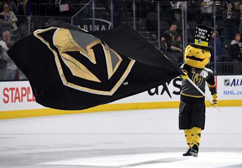 LAS VEGAS, NV – DECEMBER 31: The Vegas Golden Knights mascot Chance the Golden Gila Monster waves a Knights flag at center ice after the team defeated the Toronto Maple Leafs 6-3 at T-Mobile Arena on December 31, 2017 in Las Vegas, Nevada. (Photo by Ethan Miller/Getty Images)