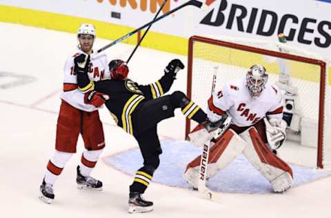 Anders Bjork #10 of the Boston Bruins gets tangled up with Dougie Hamilton #19 of the Carolina Hurricanes  (Photo by Elsa/Getty Images)