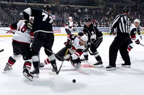 LOS ANGELES, CA – SEPTEMBER 17: Michael Caput #26 of the Arizona Coyotes falls to the ice after winning a face-off against Adrian Kempe #9 of the Los Angeles Kings during the third period of the preseason game at STAPLES Center on September 17, 2019 in Los Angeles, California. (Photo by Adam Pantozzi/NHLI via Getty Images)