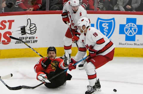 Nov 19, 2019; Chicago, IL, USA; Chicago Blackhawks center Andrew Shaw (65) and Carolina Hurricanes defenseman Dougie Hamilton (19) go for the puck during the second period at United Center. Mandatory Credit: David Banks-USA TODAY Sports