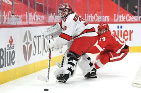 Mar 14, 2021; Detroit, Michigan, USA; Carolina Hurricanes goaltender Alex Nedeljkovic (39) clears the puck as Detroit Red Wings center Robby Fabbri (14) applies pressure during the second period at Little Caesars Arena. Mandatory Credit: Tim Fuller-USA TODAY Sports