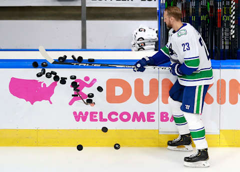 Alexander Edler #23 of the Vancouver Canucks knocks the puck onto the ice  (Photo by Jeff Vinnick/Getty Images)