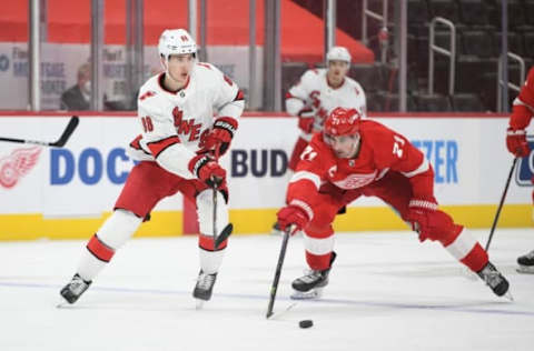 Mar 14, 2021; Detroit, Michigan, USA; Carolina Hurricanes center Martin Necas (88) passes the puck as Detroit Red Wings center Dylan Larkin (71) defends during the second period at Little Caesars Arena. Mandatory Credit: Tim Fuller-USA TODAY Sports