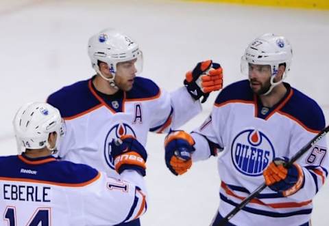 Apr 11, 2015; Vancouver, British Columbia, CAN; Edmonton Oilers forward Jordan Eberle (14) and forward Benoit Pouliot (67) celebrate forward Taylor Hall (4) goal against Vancouver Canucks goaltender Ryan Miller (30) during the second period at Rogers Arena. Mandatory Credit: Anne-Marie Sorvin-USA TODAY Sports