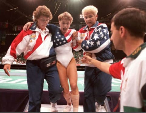 Kerri Strug screams in pain as she is carried from the floor by team officials after she injured her ankle at the Georgia Dome in Atlanta, Georgia.