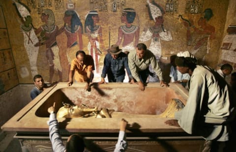 Archaeologists surrounding sarcophagus in King Tut's tomb.