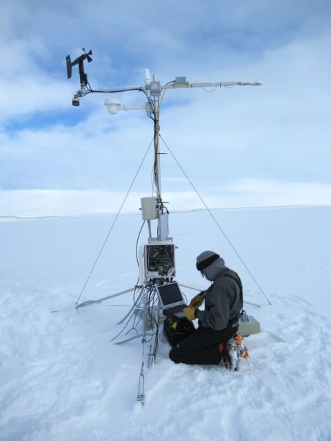 Engineer Christopher Shields downloads data from the ice monitoring station's "brain."