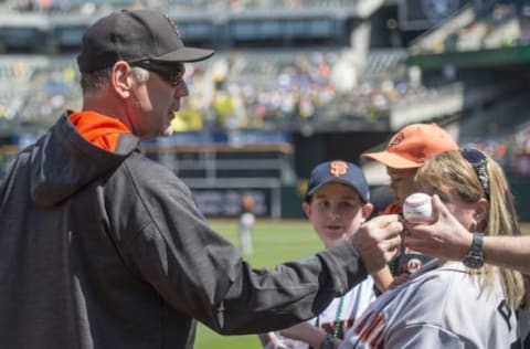 Apr 2, 2016; Oakland, CA, USA; San Francisco Giants manager Bruce Bochy (15) signs autographs for fans before the game with the Oakland A