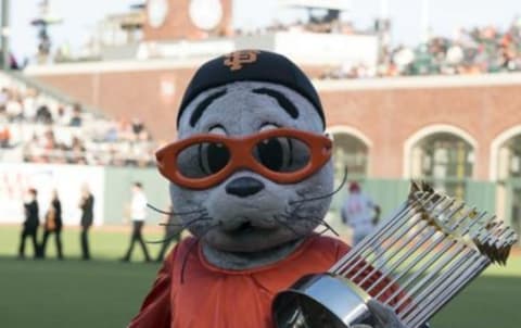 Jul 26, 2016; San Francisco, CA, USA; San Francisco Giants mascot Lou Seal holds a copy of the MLB Championship trophy before the game against the Cincinnati Reds at AT&T Park. Mandatory Credit: Kenny Karst-USA TODAY Sports